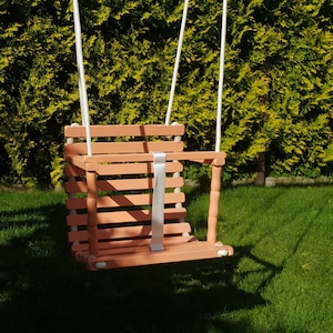 Wooden baby swing with engraved message option on the back of the swing in macchiato color made of birch wood.