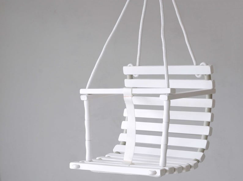 Wooden baby swing with engraved message option on the back of the swing in white color made of birch wood.
