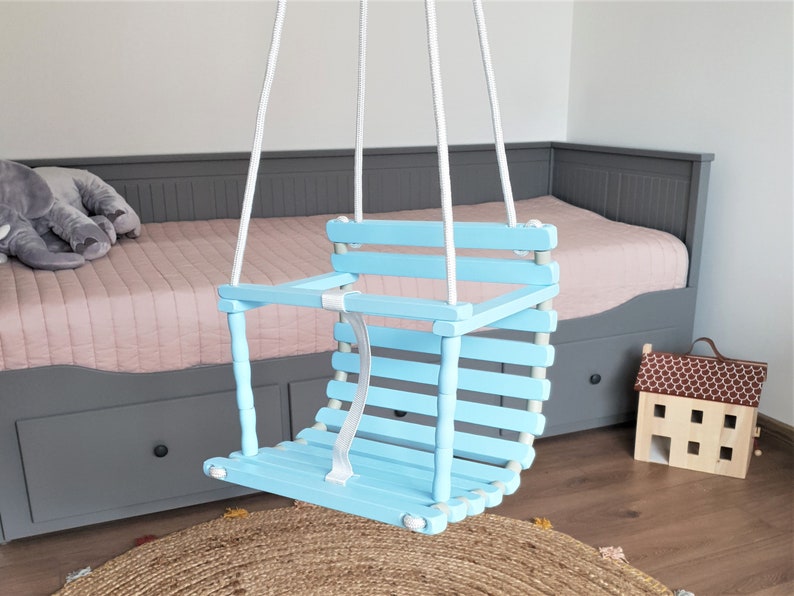 Wooden baby swing with engraved message option on the back of the swing in baby blue color made of birch wood.
