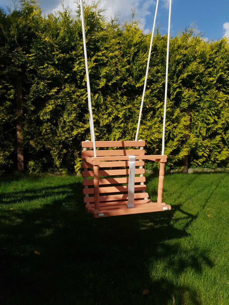 Wooden baby swing with engraved message option on the back of the swing in macchiato color made of birch wood.