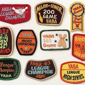 May include: A collection of ten embroidered bowling patches featuring various shapes and colours. The patches display text such as YABA League Champion, 200 Game, Most Improved, 140 Game, Bantam 250 Series, and 1982-83 League Champion, along with bowling pin and ball icons.