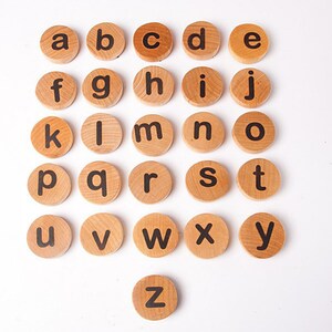 K&ouml;nnte beinhalten: Holzbrettchen mit Alphabetbuchstaben in schwarzer Schrift. Die Brettchen sind in alphabetischer Reihenfolge von A bis Z angeordnet.