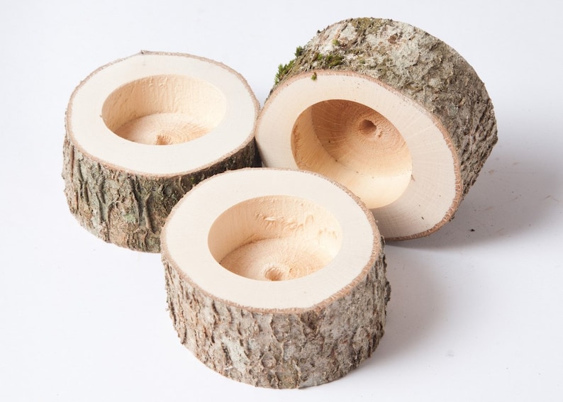 Pu&ograve; includere: Tre ciotole di legno con una finitura naturale in corteccia e un interno liscio e scavato. Le ciotole sono di dimensioni diverse e sono impilate l'una sull'altra.