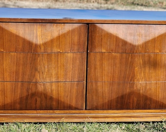 May include: A mid-century modern dresser with six drawers. The dresser is made of wood and has a light brown finish. The drawers have a diamond-shaped pattern.