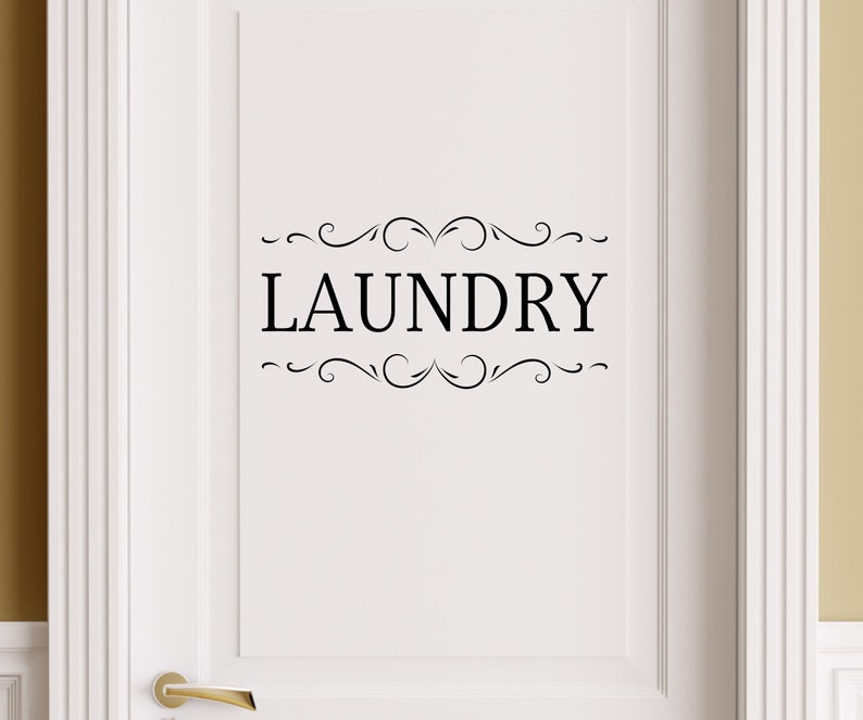 May include: White door with a black vinyl decal that says "LAUNDRY" with decorative swirls above and below the word.