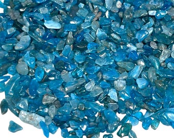 May include: A close-up view of a pile of small, polished blue-green stones. The stones vary in shape and size, with a mix of light and dark shades of blue. The surface of the stones appears smooth and reflective, with a slight sparkle.