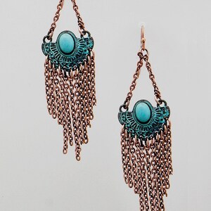 May include: A pair of dangle earrings with turquoise blue stones and copper chain fringe.