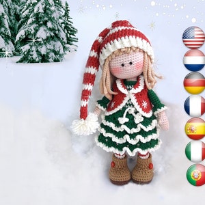 Peut inclure: Une poupée en crochet portant un chapeau rayé rouge et blanc, une robe verte avec des bordures blanches et des bottes brunes. La poupée est debout dans un paysage enneigé avec des sapins en arrière-plan.