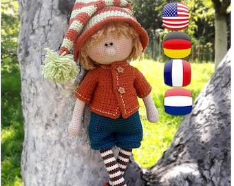 May include: A crocheted doll with a striped hat, orange sweater, blue shorts, and striped stockings. The doll is sitting on a tree trunk with a green background. The image also includes flags of the United States, Germany, France, and the Netherlands.