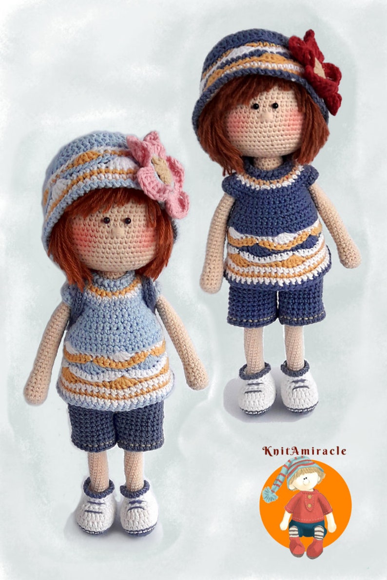May include: Two crocheted dolls wearing blue and white striped dresses and hats with flowers. The dolls have red hair and are standing on a white background. The image includes the text "KnitAmiracle".