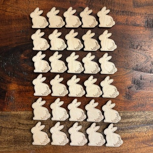May include: A set of 30 unfinished wooden bunny shapes, perfect for crafting and decorating. Each bunny is approximately 2 inches tall and features a simple, elegant design.