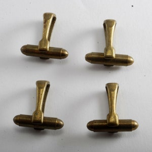 May include: Four gold-toned cufflinks with a simple design. Each cufflink has a straight bar with a loop at the top.