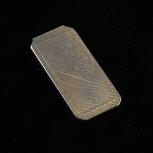 Può includere: Un fermaglio per soldi in argento con una superficie testurizzata.