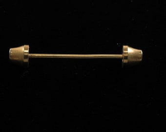 May include: A gold-toned tie bar with rounded ends. The bar is straight and has a smooth finish.