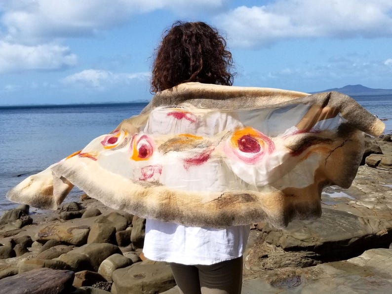 Back view of the khaki and beige felted shawl with artistic flower motifs, wearable art style.