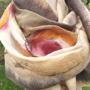 Close-up of luxurious khaki and beige merino wool and silk shawl with rose and gold felted flower accents.