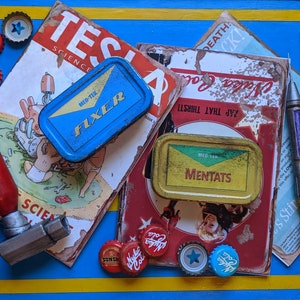 May include: A collection of vintage Fallout themed items including a red wrench, two metal tins labelled "Fixer" and "Mentats", and several bottle caps with the words "Nuka Cola" and "Sunset" printed on them. The items are arranged on a blue and yellow surface.