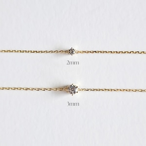 May include: Two gold chains with a single clear gemstone on each. The top chain has a 2mm stone and the bottom chain has a 3mm stone.