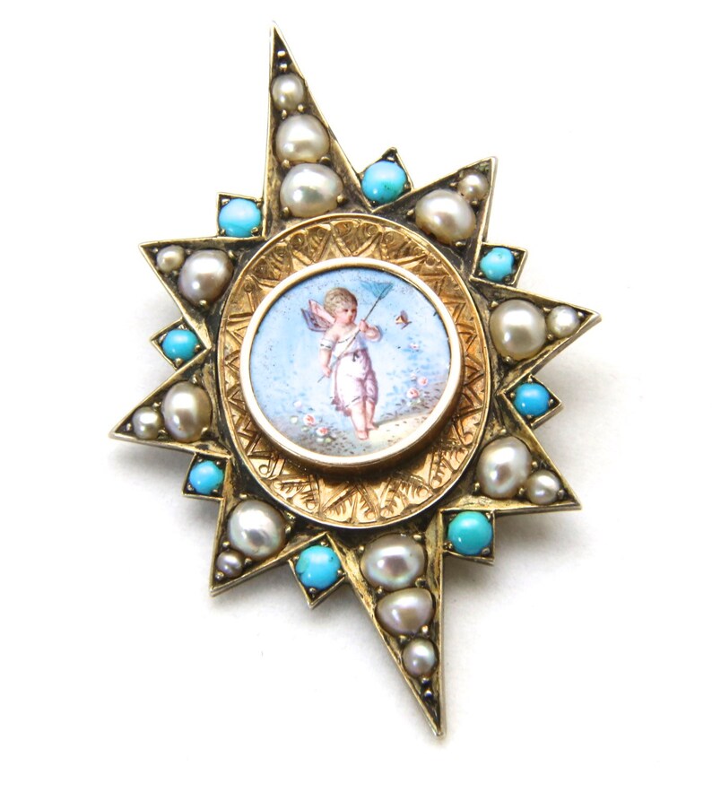 May include: A gold-toned starburst brooch featuring a central oval with a painted cherub scene. The brooch is adorned with pearls and turquoise stones. The design is intricate and detailed, with a vintage aesthetic.