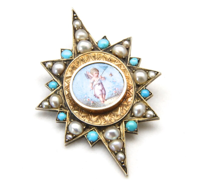 May include: A gold-toned starburst brooch featuring a central oval miniature painting of a cherub with a bow and arrow. The brooch is adorned with pearls and turquoise stones, creating a detailed and elegant design. The brooch is a vintage piece.