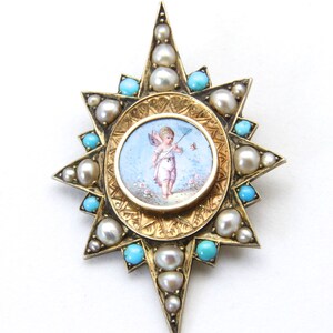 May include: A gold-toned starburst brooch featuring a central oval miniature painting of a cherub. The brooch is adorned with pearls and turquoise stones. The brooch has a detailed, ornate design.