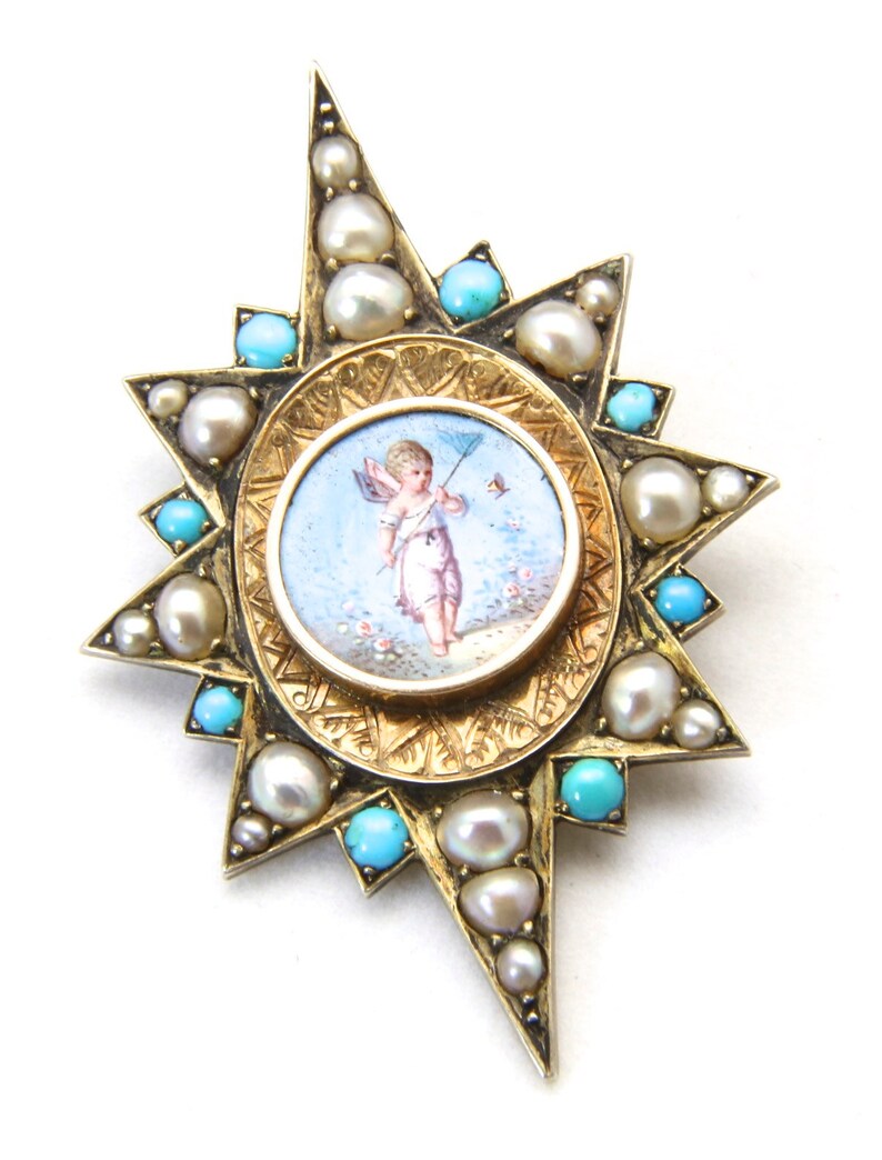 May include: A gold-toned starburst brooch featuring a central miniature painting of a cherub with a bow and arrow. The brooch is adorned with pearls and turquoise stones, creating a vintage aesthetic.