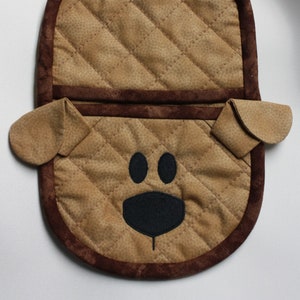 Puede incluir: Manopla de cocina acolchada marrón con forma de perro con ojos y nariz bordados en negro.