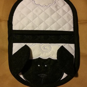 Puede incluir: Manopla para olla acolchada en blanco y negro con forma de oveja con una nube blanca en la cabeza.