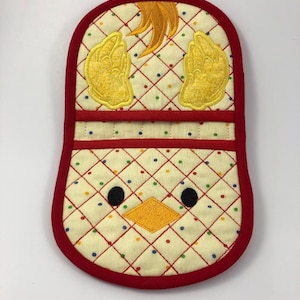 May include: A yellow chick pot holder with red trim and a polka dot pattern. The chick has black eyes, a yellow beak, and yellow wings.