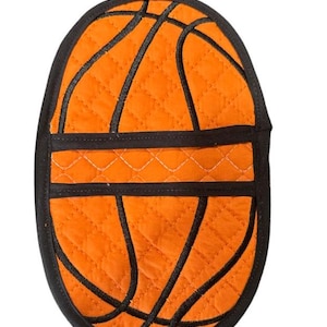 May include: Orange and black quilted oven mitt shaped like a basketball.