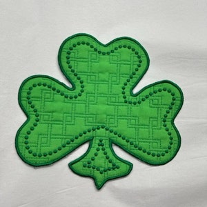 May include: A green shamrock with a patterned design, perfect for St. Patrick's Day crafts or decorations.