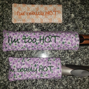 Puede incluir: Tres portaherramientas calientes acolchados de tela con estampados florales. Los portaherramientas tienen el texto "I'm really HOT" y "I'm too HOT" bordado.