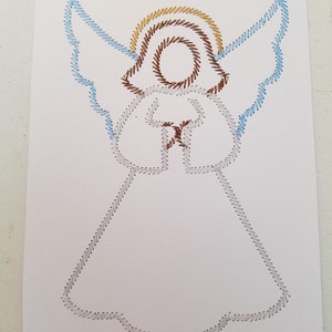 May include: A white paper with a string art design of an angel. The angel has a halo with brown and gold string, blue wings, and a white dress.