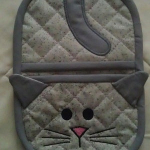 Pode incluir: Luva de forno acolchoada cinza em forma de gato com nariz rosa e olhos pretos.