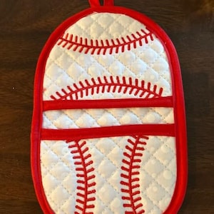 May include: Baseball-themed quilted oven mitt with a red trim and hanging loop. The mitt features a white background with red stitching mimicking a baseball design. The mitt is oval-shaped and has a quilted pattern.