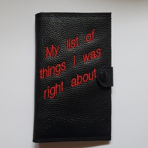 Peut inclure: Carnet en cuir noir avec une citation brodée en rouge qui dit "Ma liste de choses dont j'avais raison".