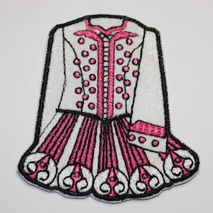 May include: White and pink embroidered Irish dance dress patch with a sparkly white fabric. The dress has a pink bodice with white polka dots and a pink skirt with white trim.