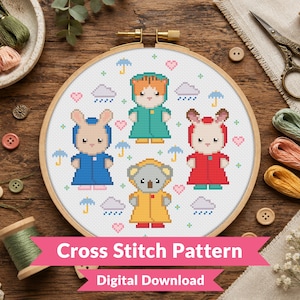 May include: A round wooden embroidery hoop containing a cross stitch pattern of four anthropomorphic animals wearing raincoats, surrounded by small umbrellas, rain clouds, and hearts. The text Cross Stitch Pattern Digital Download is visible.