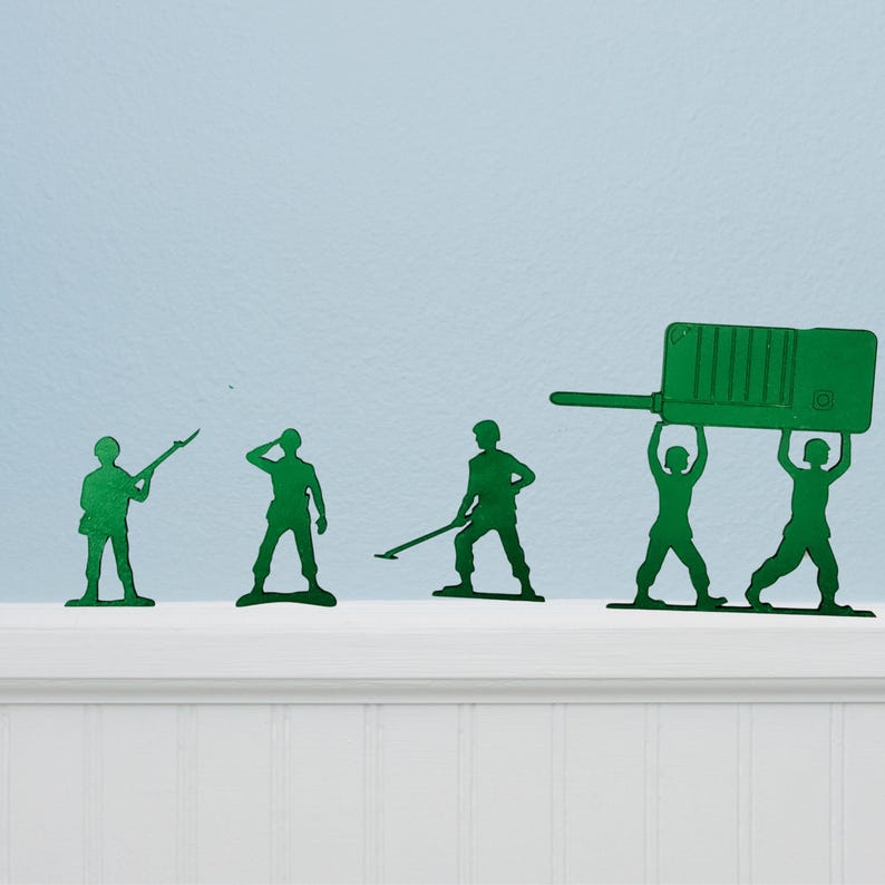 Puede incluir: Soldados de juguete de pl&aacute;stico verde en varias poses, incluido uno apuntando con un rifle y dos levantando un gran walkie-talkie verde. Los juguetes est&aacute;n colocados en un estante blanco sobre un fondo azul claro.