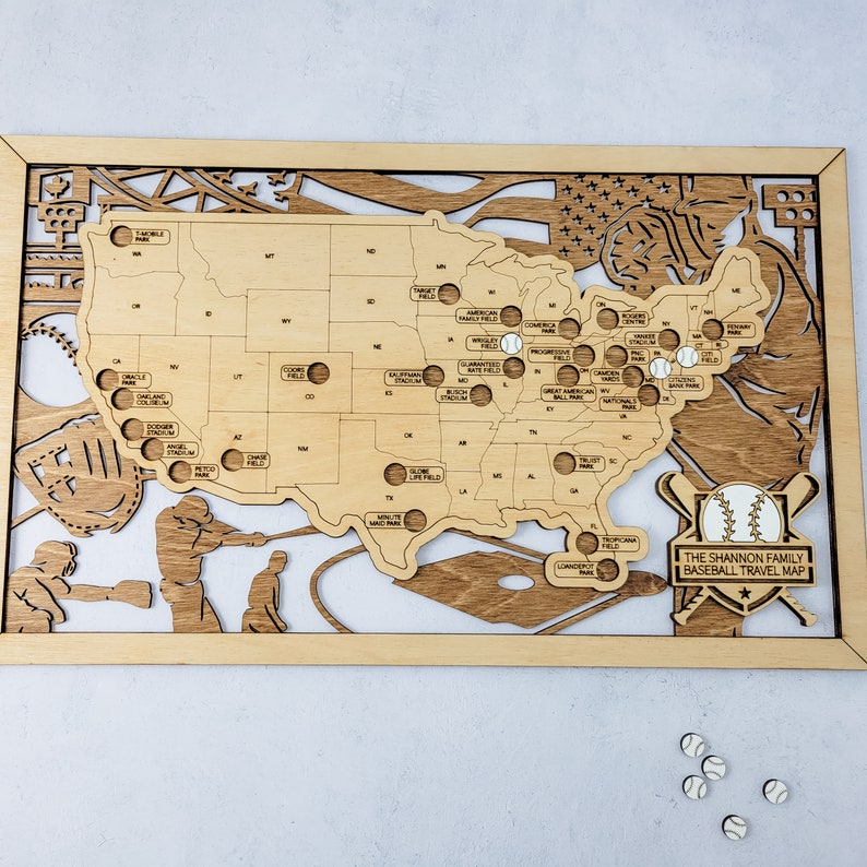 May include: A wooden map of the United States with baseball stadiums marked. The map is framed in wood and has a baseball-themed design. The text "THE SHANNON FAMILY BASEBALL TRAVEL MAP" is printed on the map.