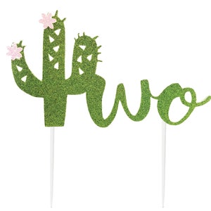 May include: Green glitter cactus cake topper with pink glitter flowers and the word "two" in green glitter.