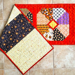 Halloween Octagons is a quilted table runner made with a variety of Halloween themed prints surrounded by pumpkin colored polka dot fabric