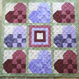 Crib and/or child's handmade quilt with 8 hearts in red, pink, lavender, and blue set with sage green sashing