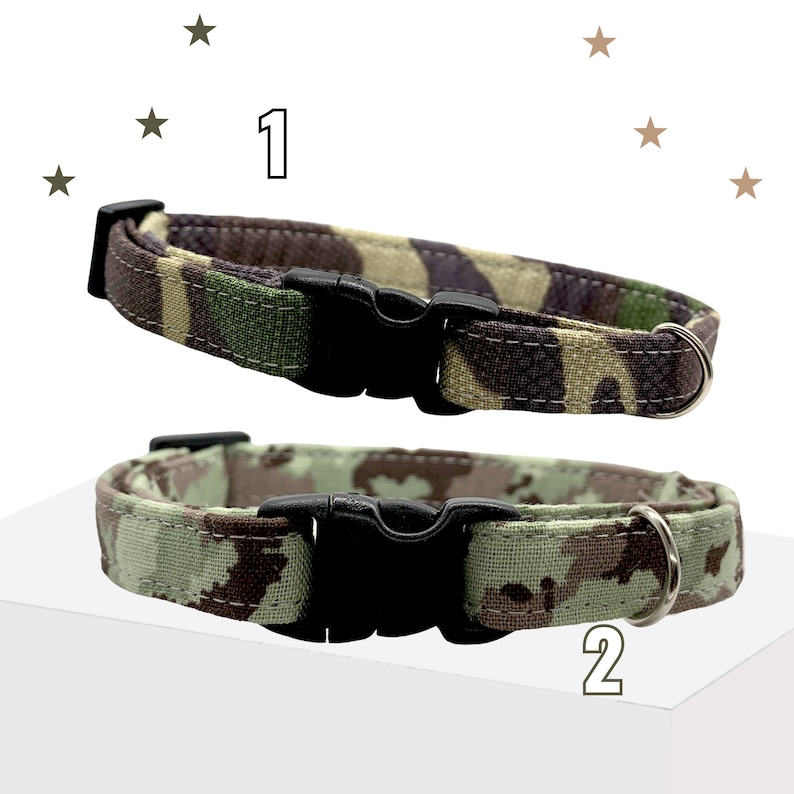 May include: Two pet collars labeled 1 and 2. Collar 1 features a dark green, brown, and black camouflage pattern. Collar 2 displays a lighter sage green, brown, and tan camouflage print. Both collars include a black plastic buckle and a metal D-ring.