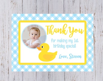 Könnte beinhalten: Eine blaue und weiße karierte Dankeskarte mit einer gelben Gummiente und einem Foto eines Babys. Die Karte sagt "Vielen Dank, dass du meinen 1. Geburtstag so besonders gemacht hast! Liebe, Steven."