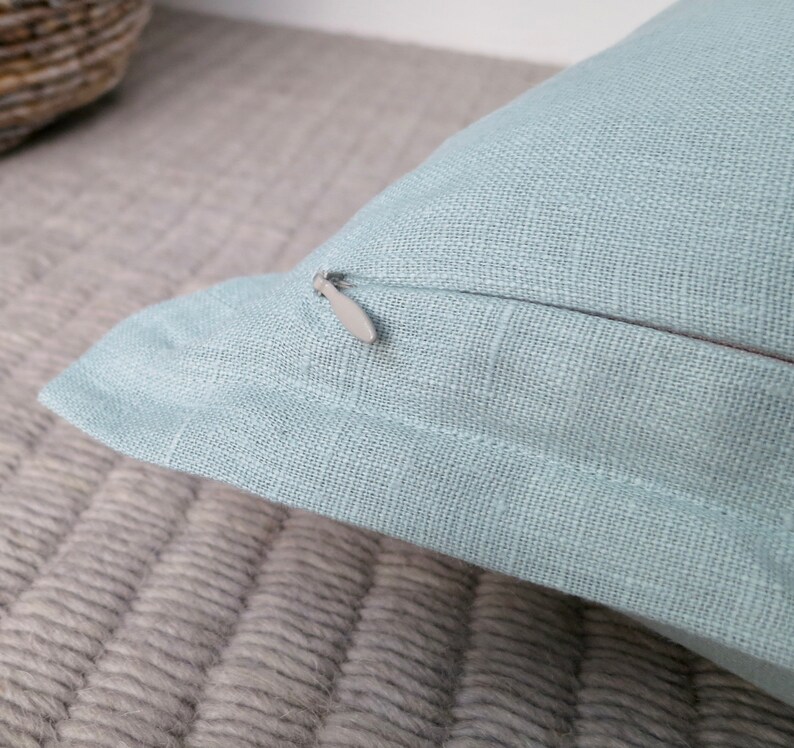May include: A light blue pillow cover with a zipper closure. The pillow cover is made of a soft, textured fabric.