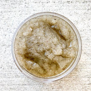 May include: A clear glass jar filled with a brown sugar scrub. The scrub has a grainy texture and a light brown color.