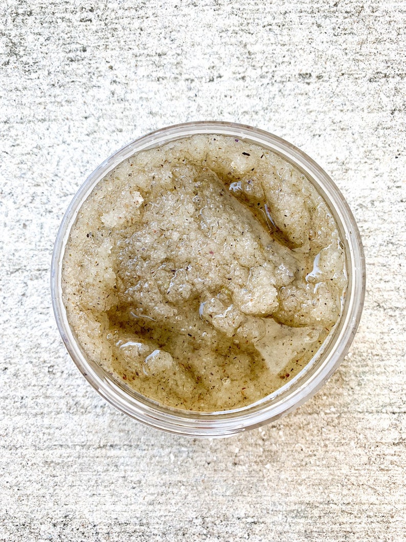 May include: A clear glass jar filled with a brown sugar scrub. The scrub has a grainy texture and a light brown color.