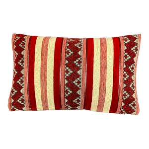 May include: Rectangular decorative pillow with a striped pattern in red and cream. The pillow features vertical red stripes alternating with cream stripes. The ends of the pillow have a geometric diamond pattern in red and black.