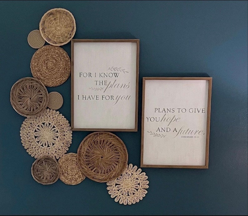 May include: Two framed inspirational quotes with a blue background. The top quote reads "For I know the plans I have for you." The bottom quote reads "Plans to give you hope and a future."  The quotes are surrounded by a decorative arrangement of woven straw circles.
